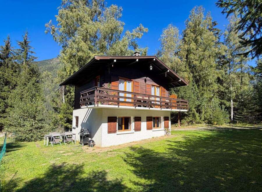 Nestled amidst lush greenery and towering trees, this charming wooden chalet offers a serene mountain retreat.