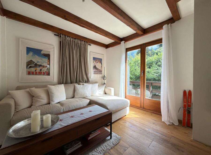Experience cozy living in this charming mountain retreat, featuring a spacious sectional sofa perfect for relaxing after a day of skiing.