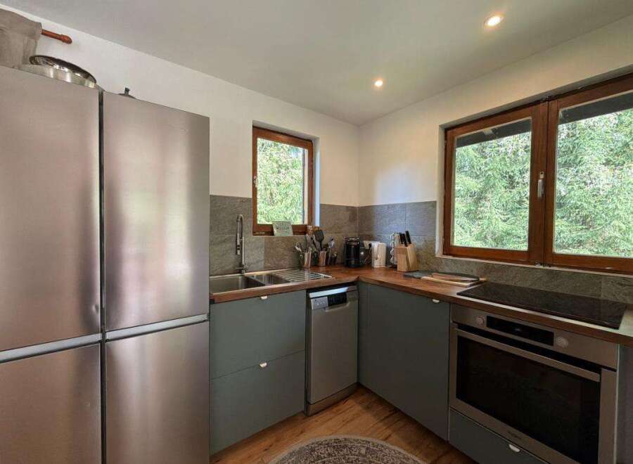 This modern kitchen boasts a sleek stainless steel refrigerator and ample counter space, perfect for meal preparation.