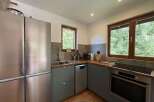 This modern kitchen boasts a sleek stainless steel refrigerator and ample counter space, perfect for meal preparation.