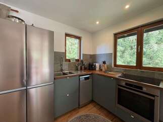 This modern kitchen boasts a sleek stainless steel refrigerator and ample counter space, perfect for meal preparation.