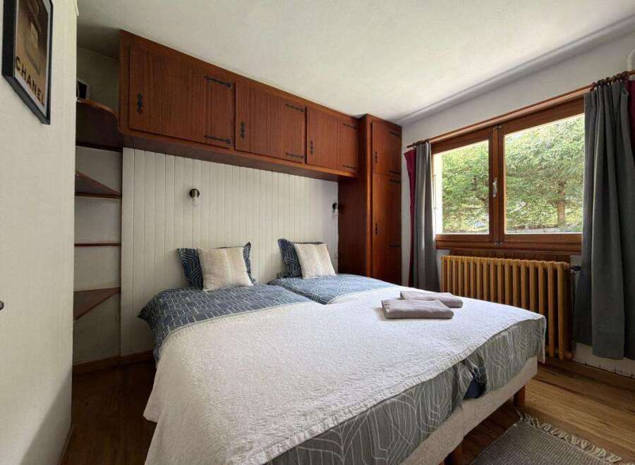 This charming bedroom features two comfortable twin beds with stylish patterned bedding and plush pillows.