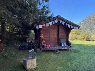 Discover this charming wooden shed, perfect for storage or as a cozy retreat.
