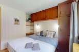 This charming bedroom features two twin beds with stylish blue and white patterned bedding, complemented by plush pillows and soft white blankets.