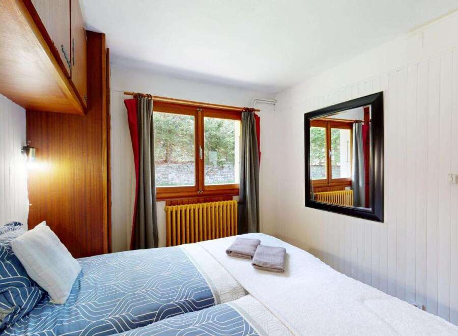 This cozy bedroom features two comfortable beds adorned with blue and white patterned bedding, perfect for a restful night's sleep.