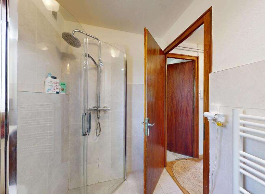 Step into this inviting bathroom featuring a spacious glass-enclosed shower with a modern showerhead, perfect for a refreshing start to your day.