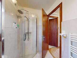Step into this inviting bathroom featuring a spacious glass-enclosed shower with a modern showerhead, perfect for a refreshing start to your day.