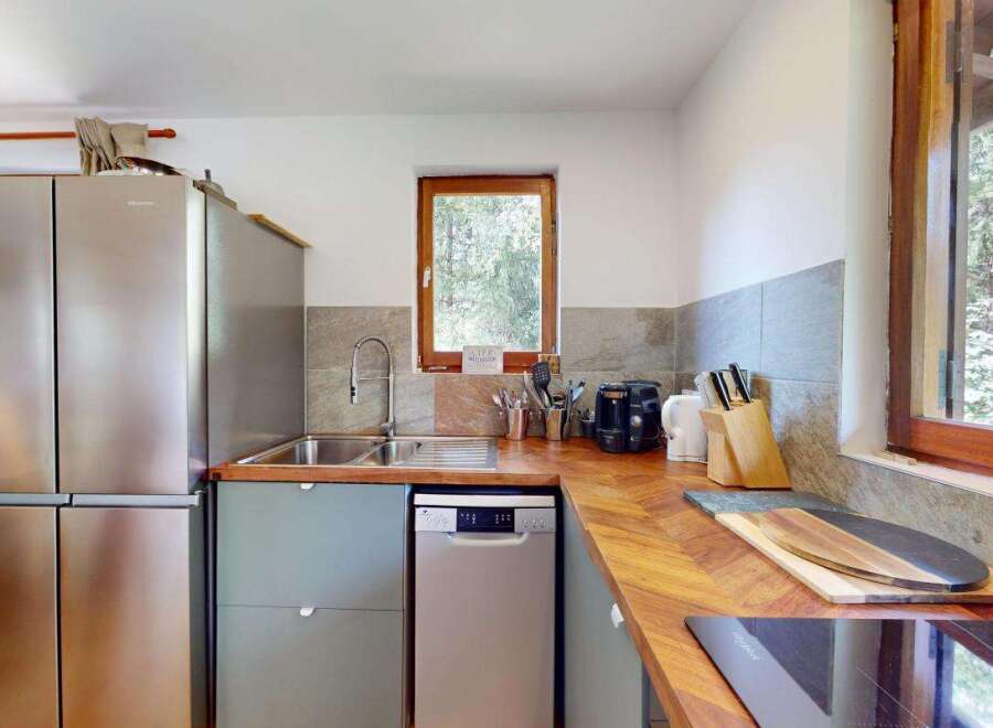 This charming kitchen features a sleek stainless steel refrigerator and a modern dishwasher, perfect for any home chef.