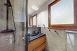 Experience modern luxury in this stunning bathroom featuring a sleek dark sink atop a warm wooden vanity.