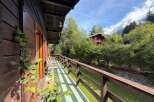 Experience the charm of this rustic wooden cabin, featuring a spacious balcony with stunning forest views.