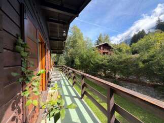 Experience the charm of this rustic wooden cabin, featuring a spacious balcony with stunning forest views.