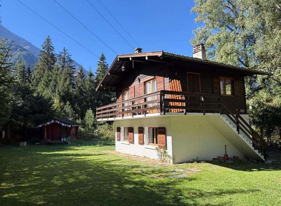 Nestled amidst a lush forest and towering mountains, this charming wooden chalet offers a serene escape.
