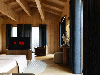 Experience ultimate relaxation in this luxurious mountain retreat, featuring a cozy bedroom with a large screen TV displaying Netflix.