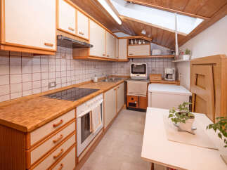 Discover this charming kitchen featuring warm wooden countertops and cabinetry, complemented by a tiled backsplash.
