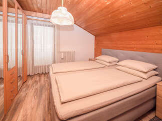 Experience cozy living in this charming bedroom featuring a comfortable bed with plush linens and a stylish headboard.