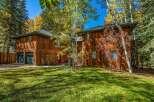 Nestled amidst a vibrant autumn forest, this stunning wooden home offers a serene retreat.