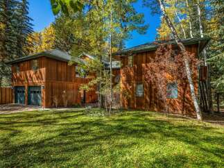 Nestled amidst a vibrant autumn forest, this stunning wooden home offers a serene retreat.