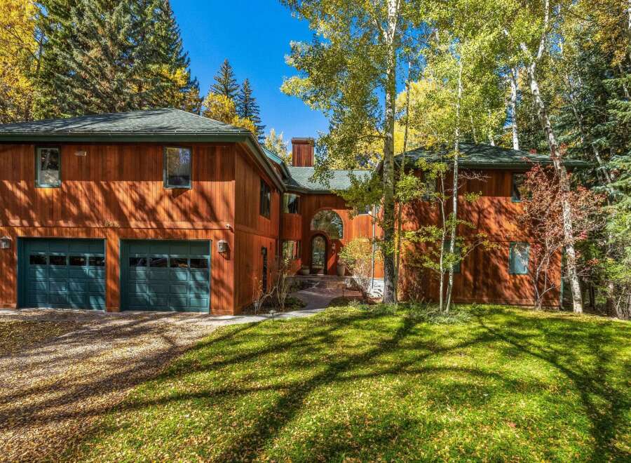 Nestled amidst a vibrant autumn landscape, this stunning wood-sided home offers a warm and inviting ambiance.