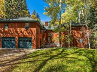 Nestled amidst a vibrant autumn landscape, this stunning wood-sided home offers a warm and inviting ambiance.
