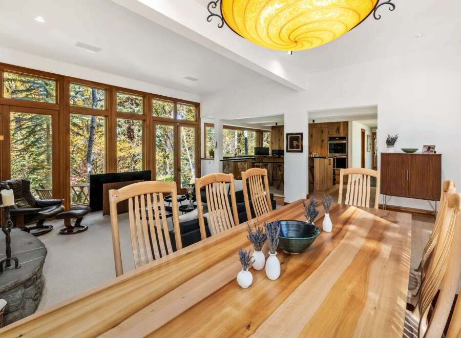 Experience luxurious living in this spacious dining and living area, featuring a large wooden dining table perfect for gatherings.