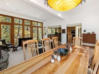 Experience luxurious living in this spacious dining and living area, featuring a large wooden dining table perfect for gatherings.