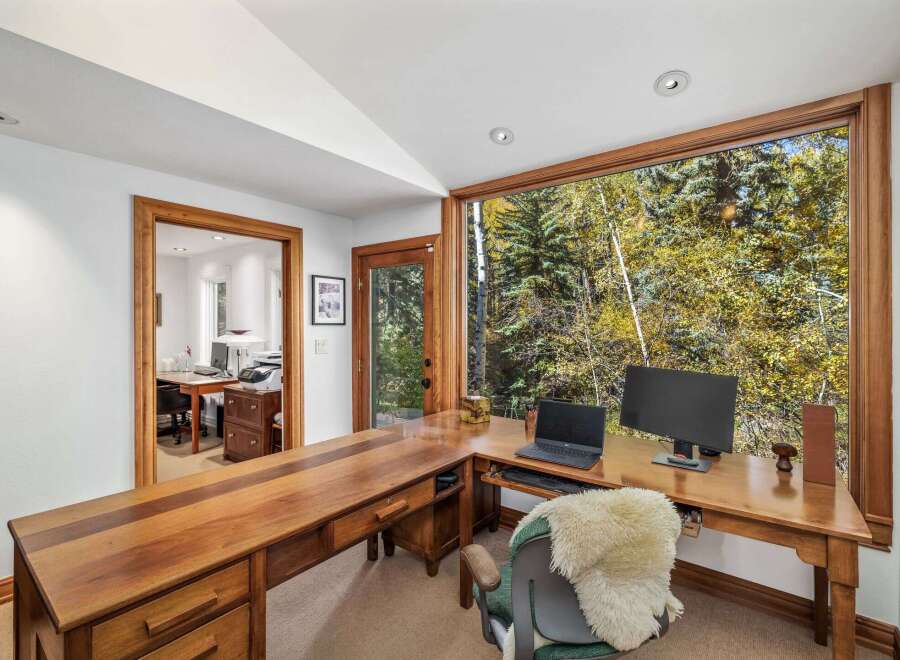 This home office boasts a spacious L-shaped wooden desk with ample storage, perfect for productivity.