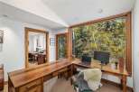 This home office boasts a spacious L-shaped wooden desk with ample storage, perfect for productivity.