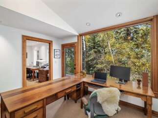 This home office boasts a spacious L-shaped wooden desk with ample storage, perfect for productivity.