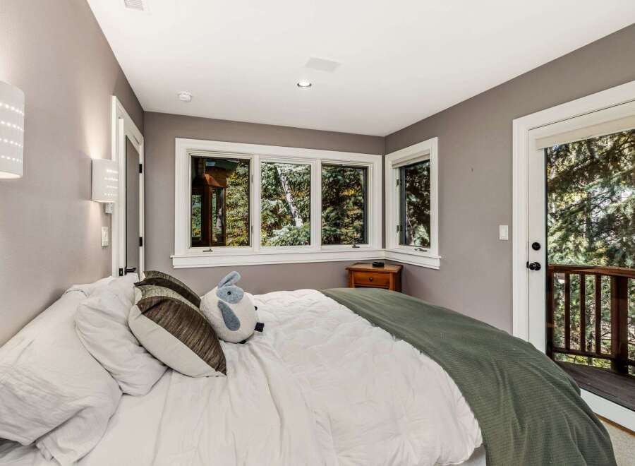 Experience serene living in this cozy bedroom, featuring a comfortable bed adorned with plush pillows and a soft green throw.