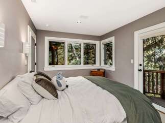 Experience serene living in this cozy bedroom, featuring a comfortable bed adorned with plush pillows and a soft green throw.