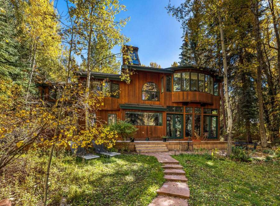 Nestled amidst vibrant autumn foliage, this stunning wood-sided home offers a serene retreat.