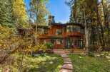 Nestled amidst vibrant autumn foliage, this stunning wood-sided home offers a serene retreat.
