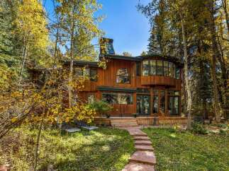 Nestled amidst vibrant autumn foliage, this stunning wood-sided home offers a serene retreat.