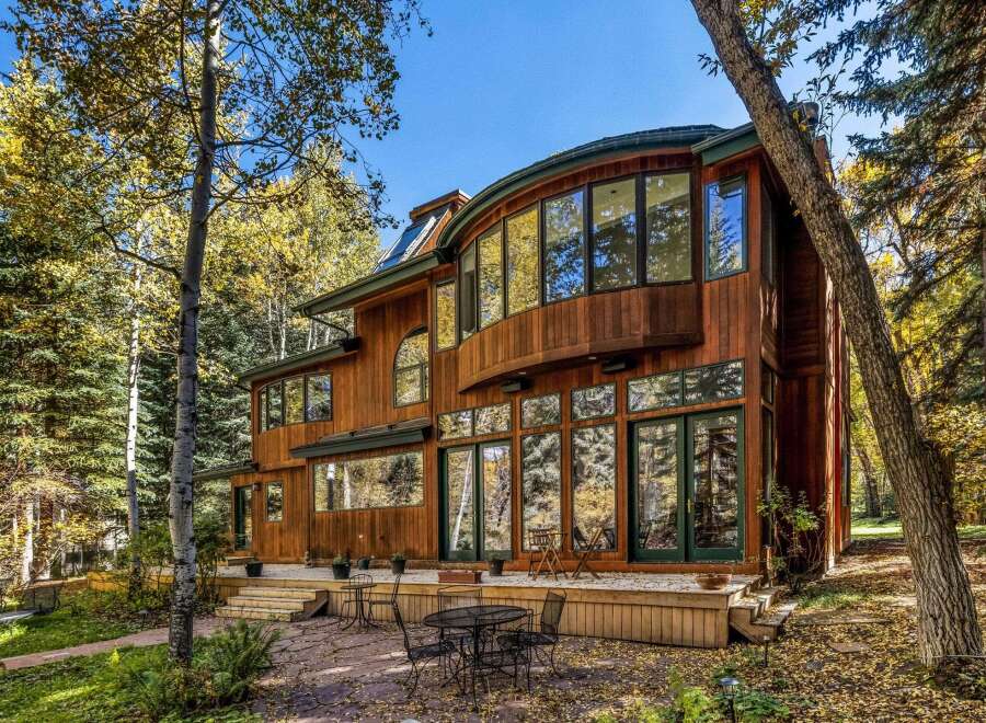 Experience luxury living in this stunning wooden home nestled amidst vibrant autumn foliage.