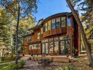 Experience luxury living in this stunning wooden home nestled amidst vibrant autumn foliage.