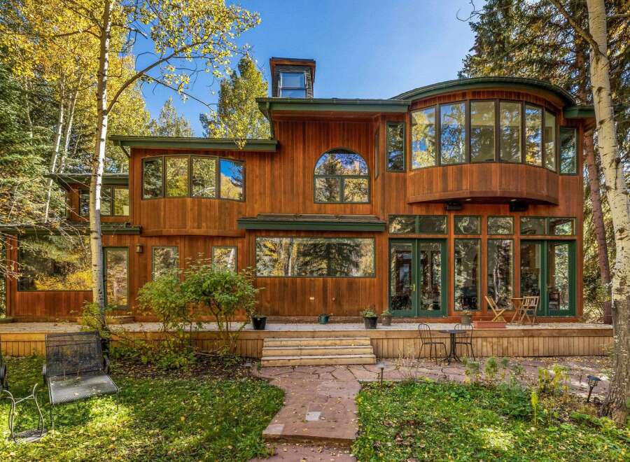 Nestled amidst vibrant autumn foliage, this stunning wooden home offers a serene retreat.