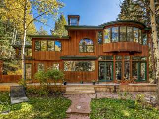 Nestled amidst vibrant autumn foliage, this stunning wooden home offers a serene retreat.