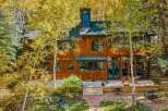Nestled amidst vibrant autumn foliage, this stunning wooden home offers a serene retreat.