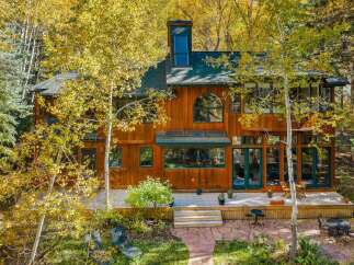 Nestled amidst vibrant autumn foliage, this stunning wooden home offers a serene retreat.