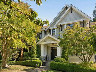 Discover this stunning home featuring a charming covered entryway with white columns and a black front door, perfect for welcoming guests.