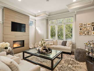 Experience luxury living in this stunning living room, featuring a modern gas fireplace with a sleek tile surround and a mounted flat-screen TV.