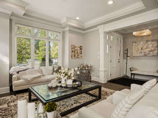Step into this elegant living room, featuring a plush sectional sofa adorned with cozy throws and decorative pillows.