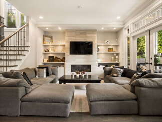 Experience modern luxury in this spacious living room, featuring a sleek fireplace and a mounted television as the focal point.