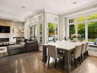 Experience luxurious open-concept living in this stunning home, featuring a modern fireplace and a spacious dining area perfect for entertaining.