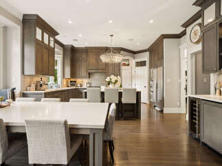 Experience luxury in this stunning kitchen, featuring custom dark wood cabinetry and a large island perfect for entertaining.
