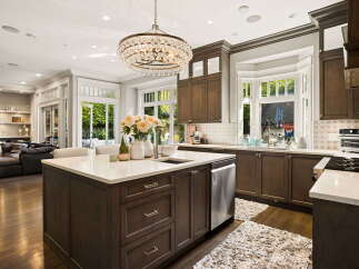 Experience luxury in this stunning gourmet kitchen, featuring a spacious island with a waterfall countertop and a farmhouse sink.