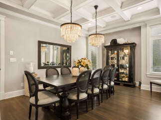 Experience elegant dining in this sophisticated formal dining room, featuring a grand dark wood table with seating for eight, illuminated by two stunning crystal chandeliers.