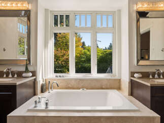 Indulge in luxury with this stunning bathroom featuring a spacious soaking tub perfect for relaxation.