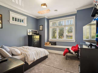 This charming bedroom features a comfortable bed with striped bedding, perfect for a restful night's sleep.