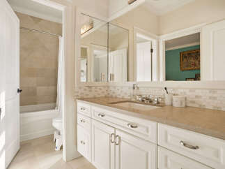 This elegant bathroom features a spacious vanity with ample storage and a beautiful stone countertop.